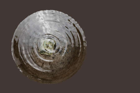 Water in a large metal container, a textural image of mixing liquid with a torn dollar billの写真素材