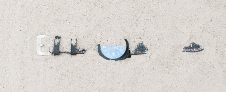 A wristwatch with a leather bracelet lies lost in the sand on the beach