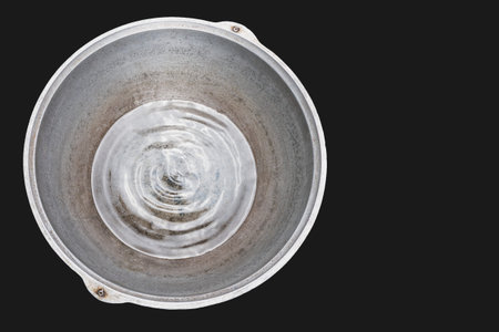Water in a large metal container, a textural image of the agitation of the liquid