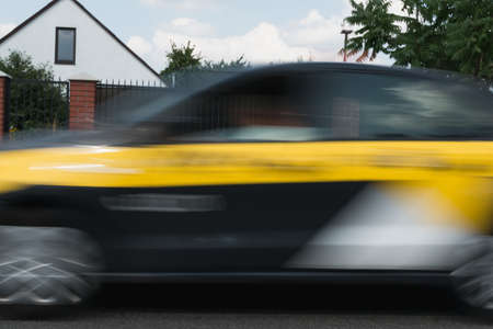 A blurry image of a car moving along a city streetの写真素材