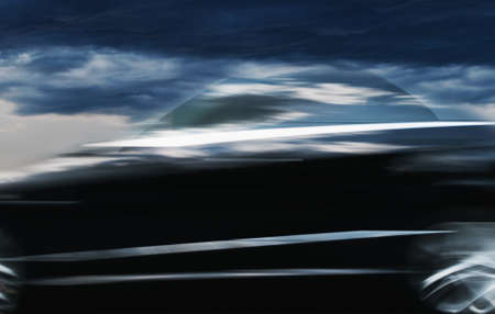 A blurry image of a car moving along a city streetの写真素材