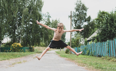 A little boy walks around the village barefoot and without a T-shirtの写真素材