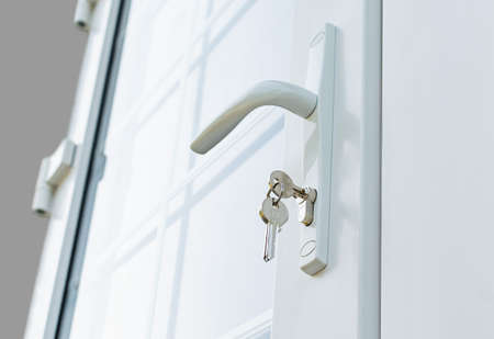New plastic window with white partitions and a handle with a lock, in a country houseの写真素材