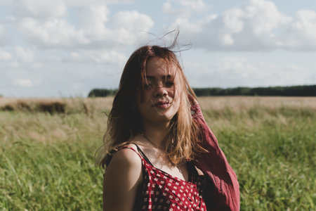 The image of a young girl against the background of a country evening landscapeの写真素材