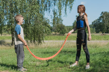 Sister plays with her brother on the street with a rubber toy