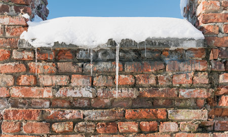 The ruins of a ruined brick fortress under the snow, on a sunny dayの写真素材