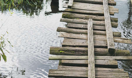 An old wooden bridge over a small riverの写真素材