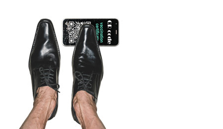 The legs of an adult man in model shoes and a crushed smartphone