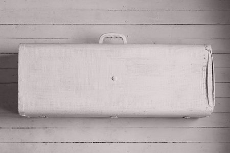 An old suitcase with a handle painted whiteの写真素材