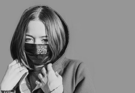 A young girl in a warm coat wearing a protective medical mask