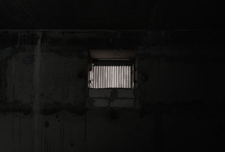 A small window in the dark basement of the house