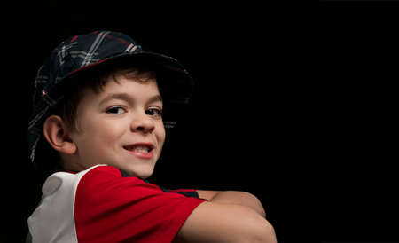 A little boy with brown eyes poses on a dark backgroundの写真素材