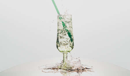 Glass tumbler with bubbling water on a white backgroundの写真素材