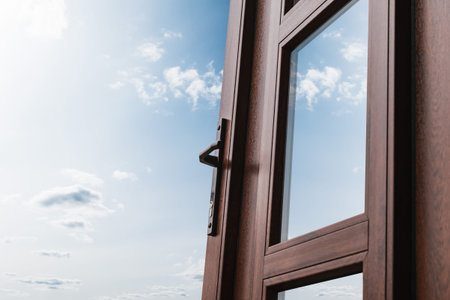 A fragment of a new plastic door with a handle covered with lamination