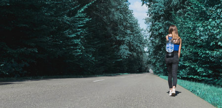 A young girl carries a large bottle of clean water along the road