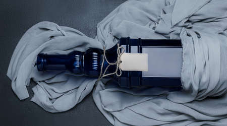 Decorative bottle wrapped in textile with a tagの写真素材