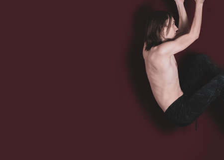 A young guy with a naked torso is engaged in sports exercisesの写真素材