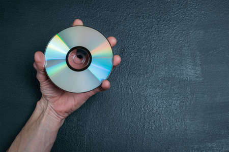 The man's hands hold a new CD with informationの写真素材