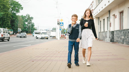 Little boy and sister walking around the city and eating ice creamの写真素材