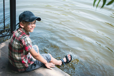 A little boy walks in the park, wetting his feet in waterの写真素材