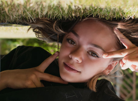A young girl walks on puddles in the yard of the houseの写真素材
