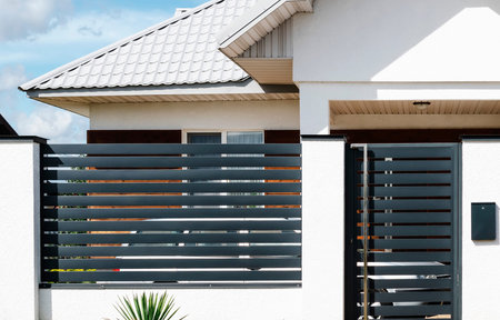 New fence made of metal profile of a country house