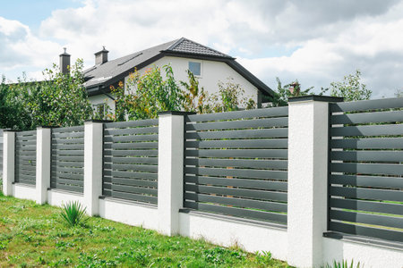 Country house with new roof, fence and garden treesの写真素材