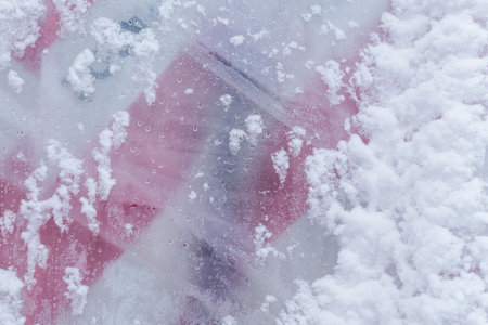 Plastic film covered with raindrops and snowの写真素材