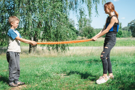 brother and sister play with a rubber toy on the streetの写真素材
