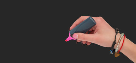 The girl's hand holds a felt-tip pen on a dark background