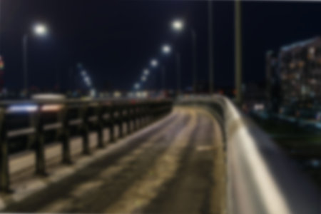 A blurry image of a night city with a car bridgeの写真素材