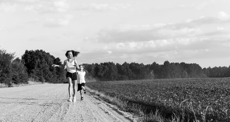 Brother and sister play and run along a country roadの写真素材