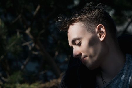 Portrait image of a young man in the garden on a sunny day