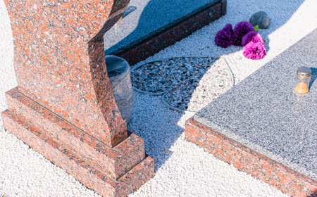 A fragment of a granite monument in a large cemetery