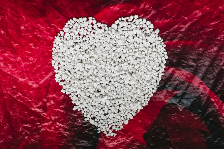 Textural image of scattered granules of white food substance in the form of a heartの写真素材