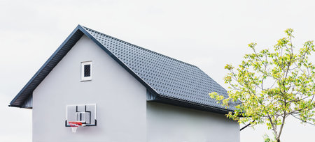 A small building in the courtyard of a private house with a basketball hoop on the wallの写真素材