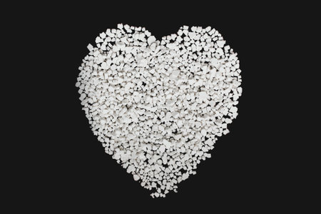 Textural image of scattered granules of white food substance in the form of a heartの写真素材