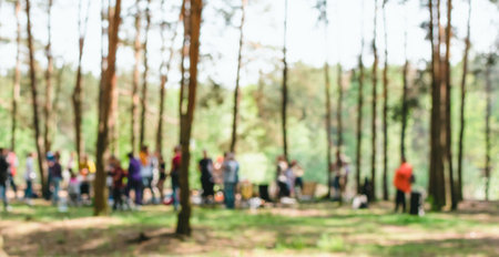 A blurry image of a lot of people relaxing in a pine forestの写真素材