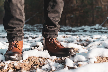 A man in new boots walks along a snowy road outside the cityの写真素材