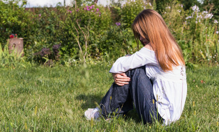Portrait image of a young girl in a white blouse, with long hair in a summer gardenの写真素材