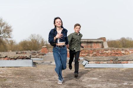 Sister and younger brother walking in the park near the old fortressの写真素材