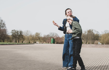 Sister and younger brother walking in the park near the old fortressの写真素材