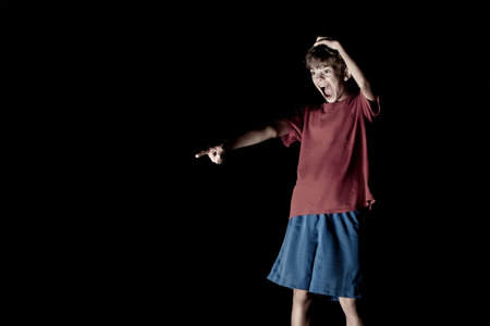 Portrait image of a boy at night in the dark with one light sourceの写真素材