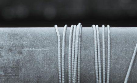 The metal cable for the well is wound on a piece of pipeの写真素材