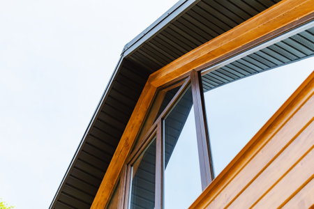 A fragment of a restored old village house with new windows and roof