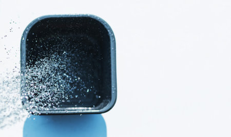 Splashes of water pouring from a tap into a plastic containerの写真素材