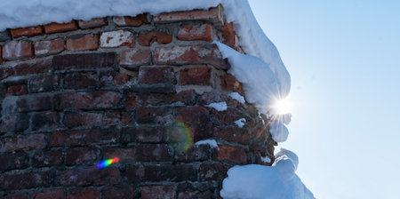 A fragment of the brick wall of the old fortress covered with snowの写真素材