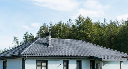 A fragment of a private residential building with a new roof and windows outside the city