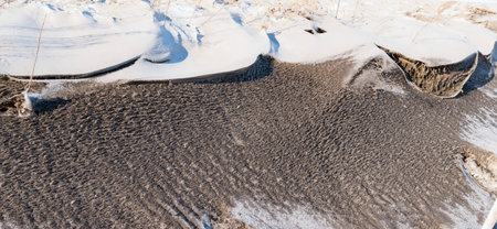 Thick snow on the side of the road, covered with mud