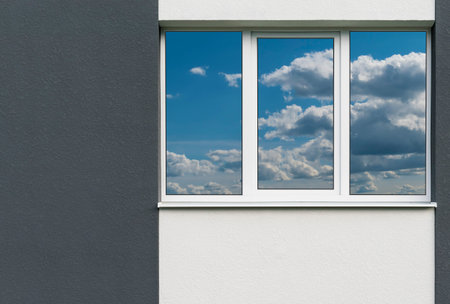 A fragment of a new private plastered house with white windows